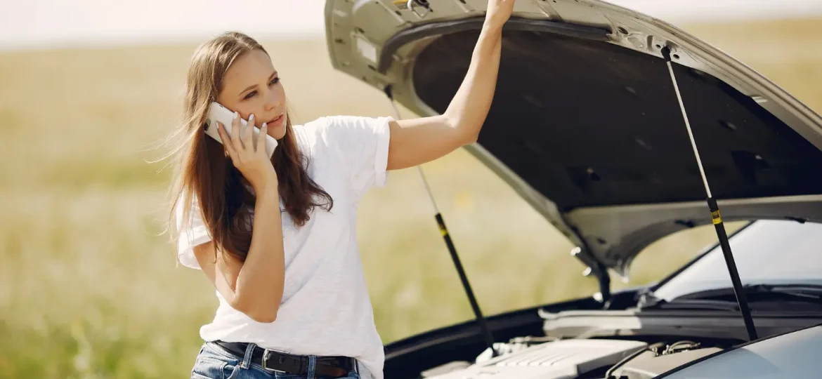 femme qui appelle une dépanneuse au bord de la route après une panne de voiture