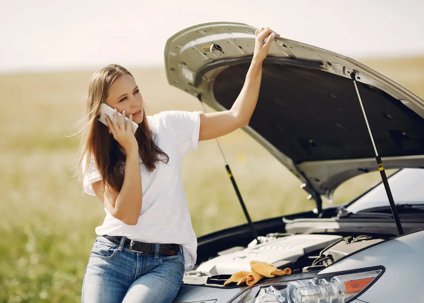 femme qui appelle une dépanneuse au bord de la route après une panne de voiture