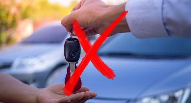 Vente de voiture échec illustrée par une main qui tend une clé à une personne avec une croix rouge