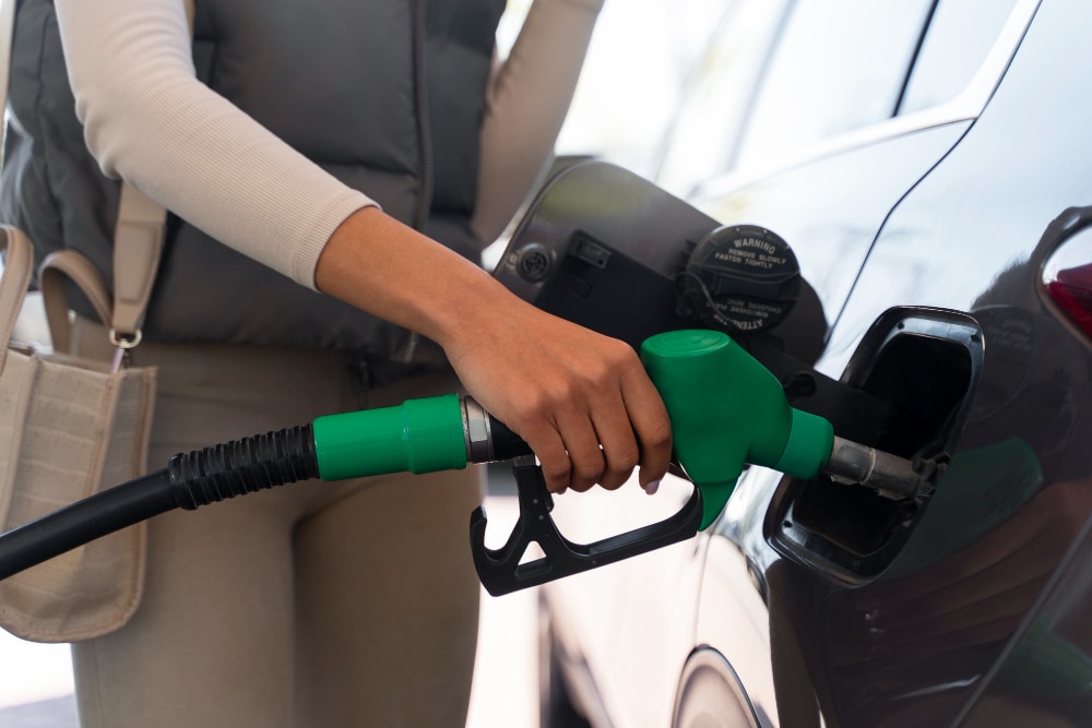 un conducteur qui fait le plein de biocarburant pour sa voiture en station service