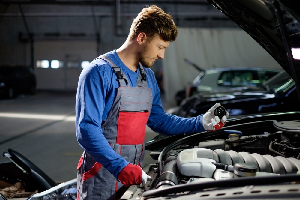 Un garage qui contrôle une voiture capot ouvert lors du contrôle technique