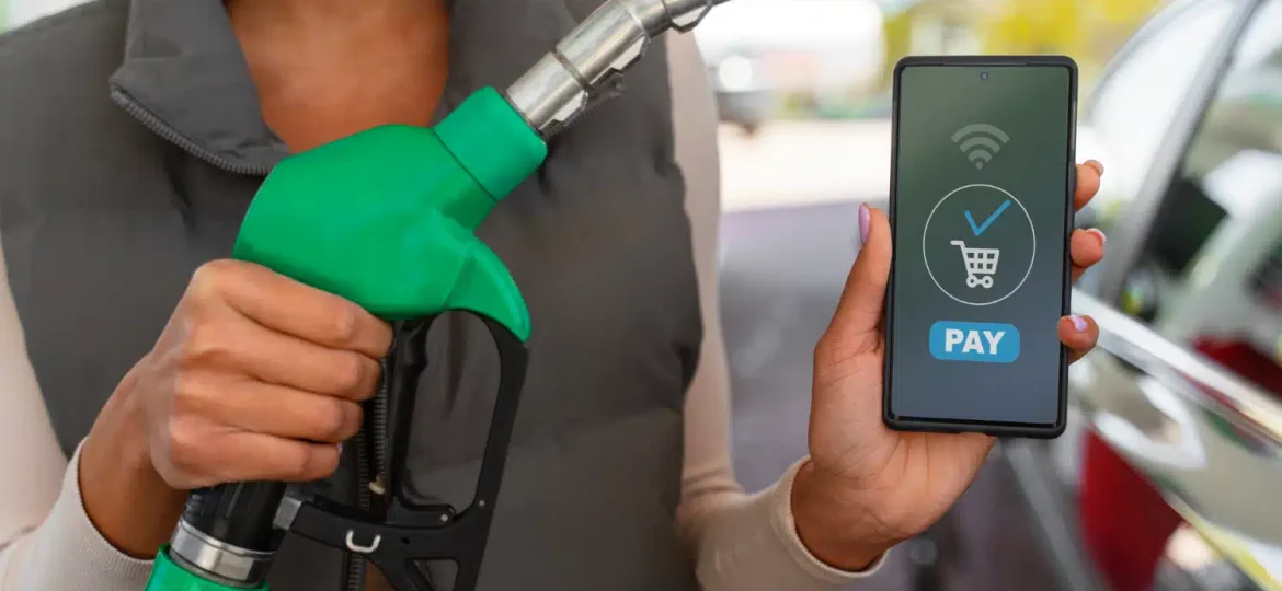 une panne à la station service qui tient un son téléphone pour payer du carburant