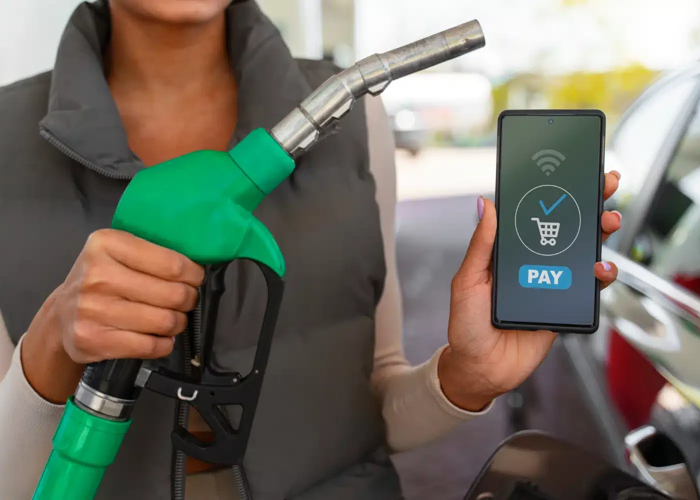 une panne à la station service qui tient un son téléphone pour payer du carburant