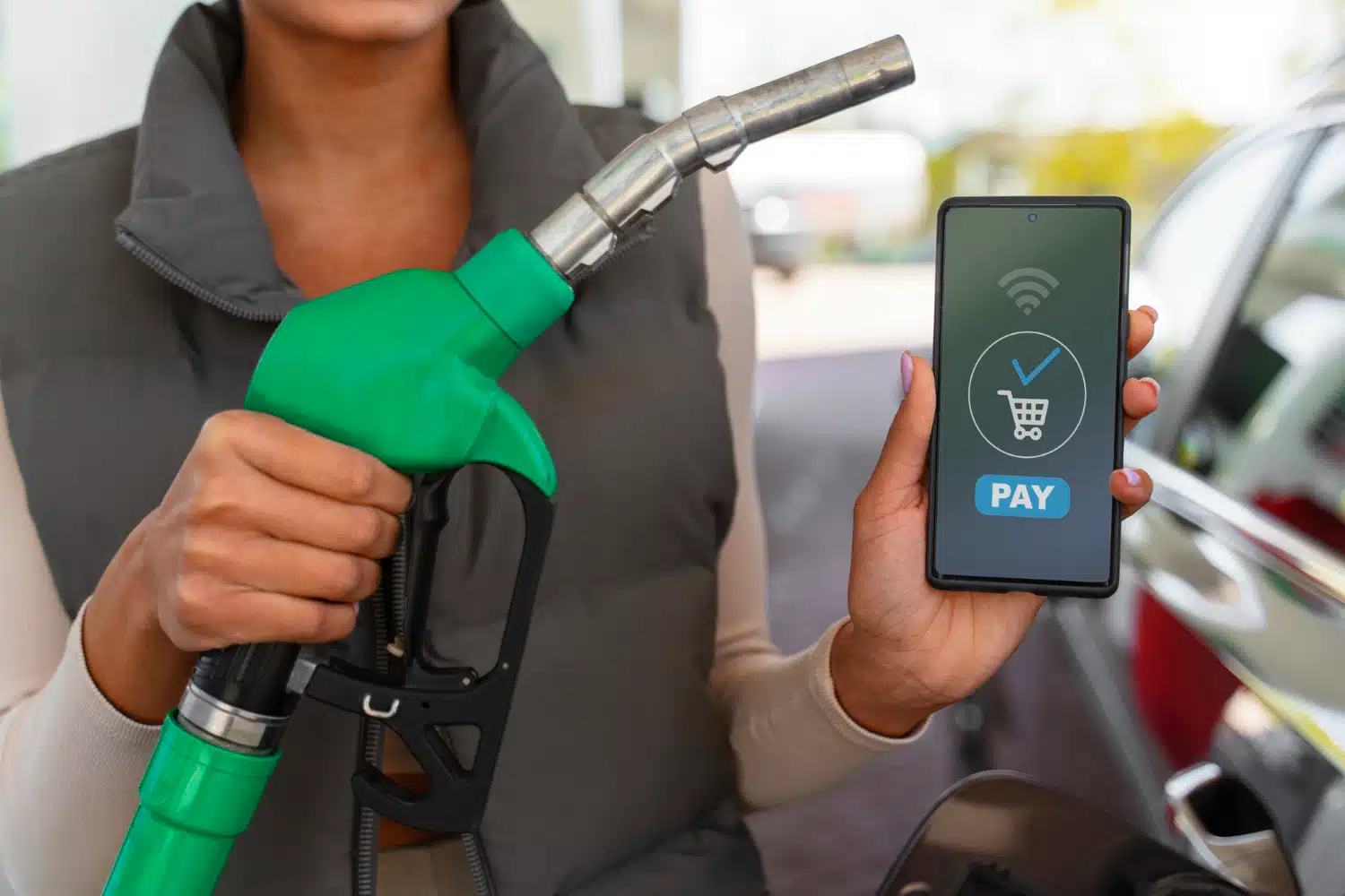 une panne à la station service qui tient un son téléphone pour payer du carburant