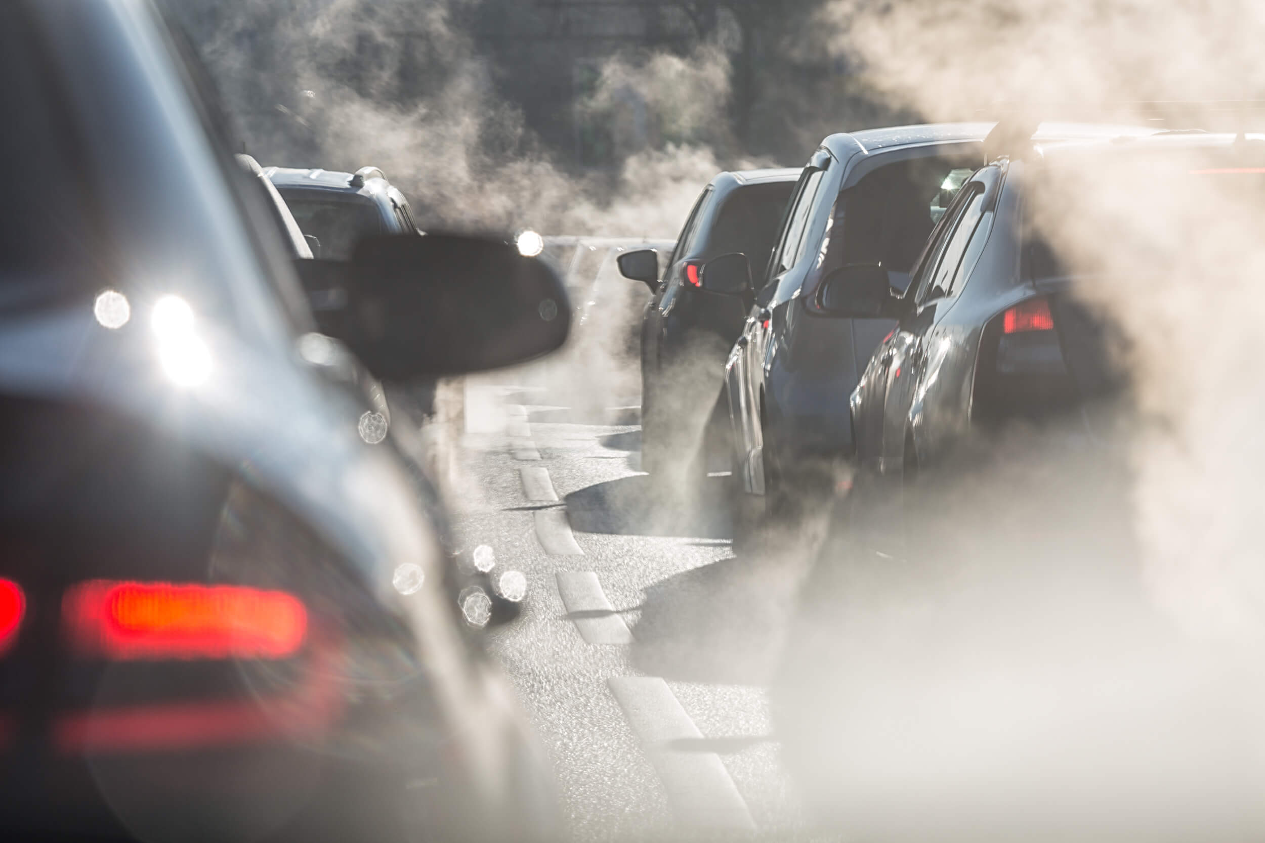 Des voitures dans un embouteillages qui polluent avec de la fumée blanche